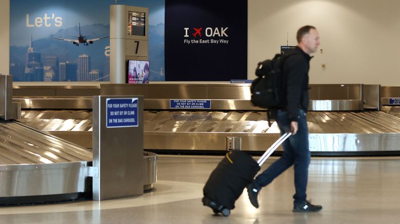 OAKLAND, CALIFORNIA - APRIL 12: A traveler walks through baggage claim in Terminal 2 at Oakland International Airport on April 12, 2024 in Oakland, California. The Board of Commissioners for the Port of Oakland voted on Thursday to proceed with a plan to change the name of Oakland International Airport to the San Francisco Bay Oakland International Airport. San Francisco officials are objecting to the proposed name change and have threatened to file a lawsuit arguing it would violate the cityâs trademark on San Francisco International Airport and would potentially be confusing for people traveling to the area. (Photo by Justin Sullivan/Getty Images)