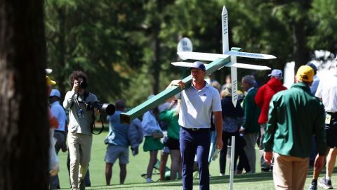 Bryson DeChambeau of the United States moves a sign while preparing to play his second shot on the 13th hole from the 14th fairway during the second round of the 2024 Masters Tournament at Augusta National Golf Club on April 12, 2024 in Augusta, Georgia.