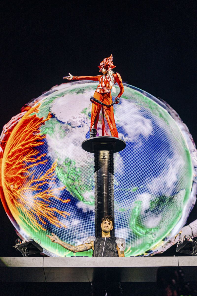Grimes accompanied DJ Anyma at the Sahara Stage during weekend one, wearing a sheer red Dion Lee maxi skirt and warrior helmet.