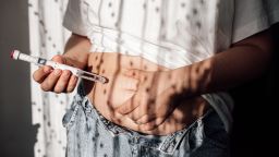 Injections for weight loss. A woman gives a hormone glucagon-like peptide-1 (GLP-1) injection into the abdomen with a pen syringe.