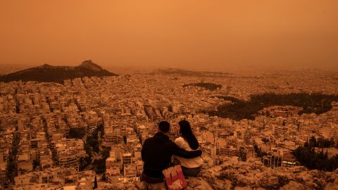 A couple sits on Tourkovounia hill in Athens, as southerly winds carry waves of Saharan dust to Greece,  on April 23, 2024.