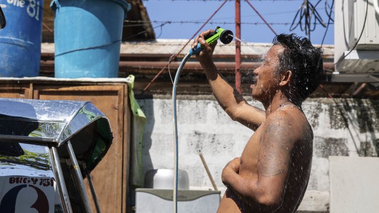 A man showers with a hose during hot weather in Manila on April 28, 2024. The Philippines will suspend in-person classes in all public schools for two days due to extreme heat and a nationwide strike by jeepney drivers, the education department said on April 28. (Photo by Earvin Perias / AFP) (Photo by EARVIN PERIAS/AFP via Getty Images)