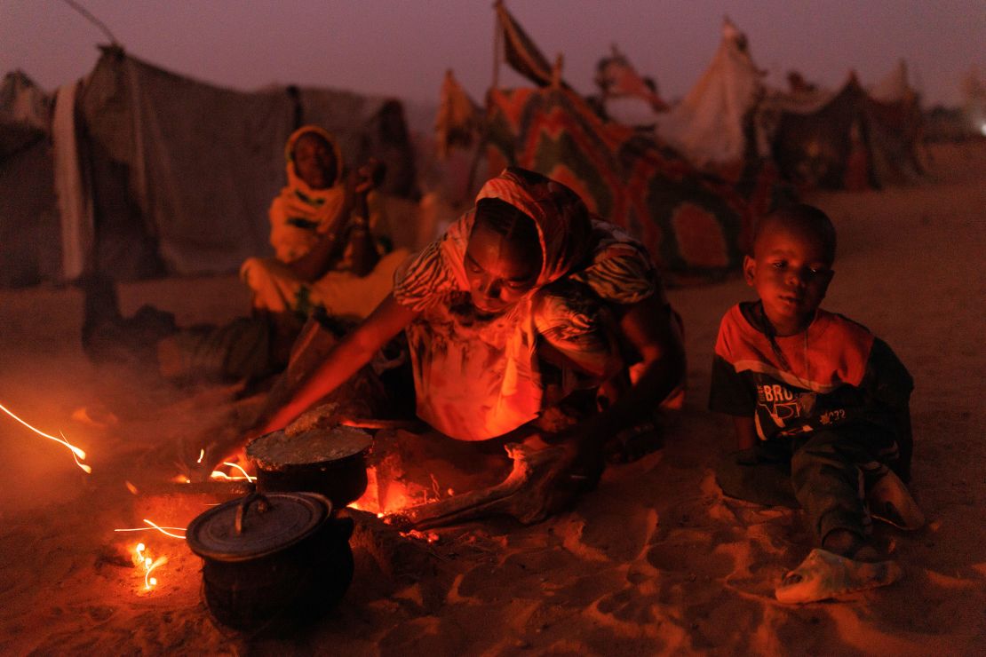 Newly arrived refugees from Sudan cook food over fires outside their makeshift shelters, on April 24, 2024 near Adré, Chad.