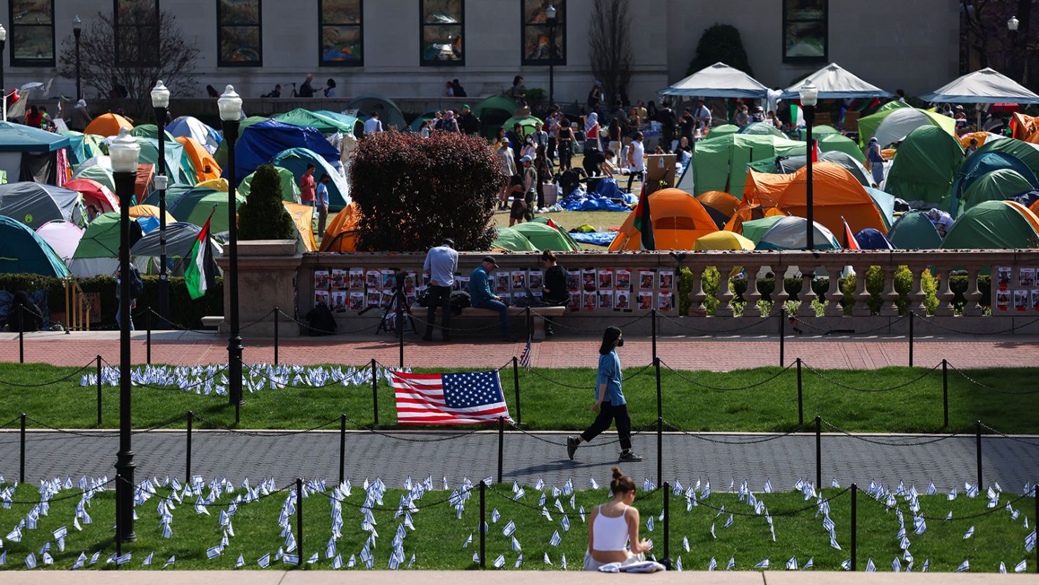 A woman walks past Israeli and US flags alongside portraits of Israelis taken hostage by the militant Palestinian group Hamas in front of the pro-Palestinian encampment at the Columbia University on April 28 in New York City.