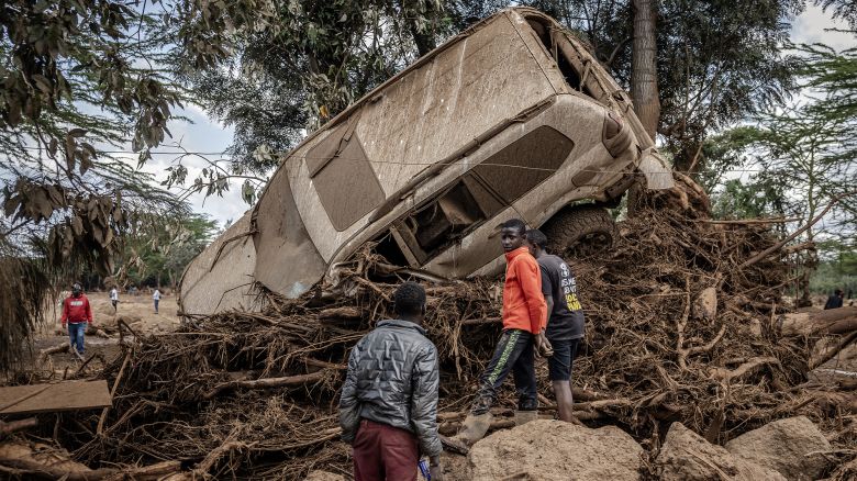 TOPSHOT - Young men inspect a destroyed car carried by waters in an area heavily affected by torrential rains and flash floods in the village of Kamuchiri, near Mai Mahiu, on April 29, 2024. At least 45 people died when a dam burst its banks near a town in Kenya's Rift Valley, police said on April 29, 2024, as torrential rains and floods battered the country.
The disaster raises the total death toll over the March-May wet season in Kenya to more than 120 as heavier than usual rainfall pounds East Africa, compounded by the El Nino weather pattern. (Photo by LUIS TATO / AFP) (Photo by LUIS TATO/AFP via Getty Images)