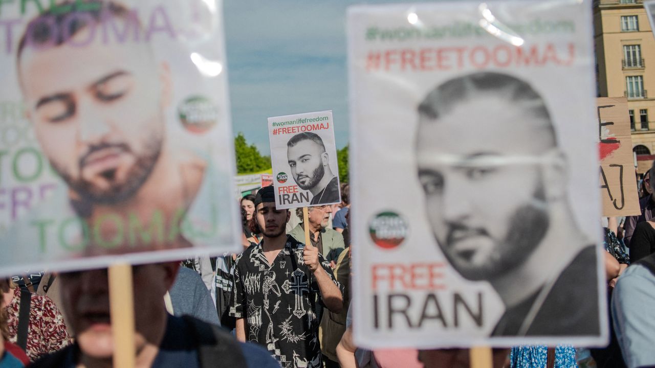 Protesters hold signs during a rally protesting against a death sentence given to Toomaj Salehi, a famous Iranian rapper, after Iranian courts accused him of singing pro-women-led protests in Berlin, Germany, on Sunday, April 28, 2024.