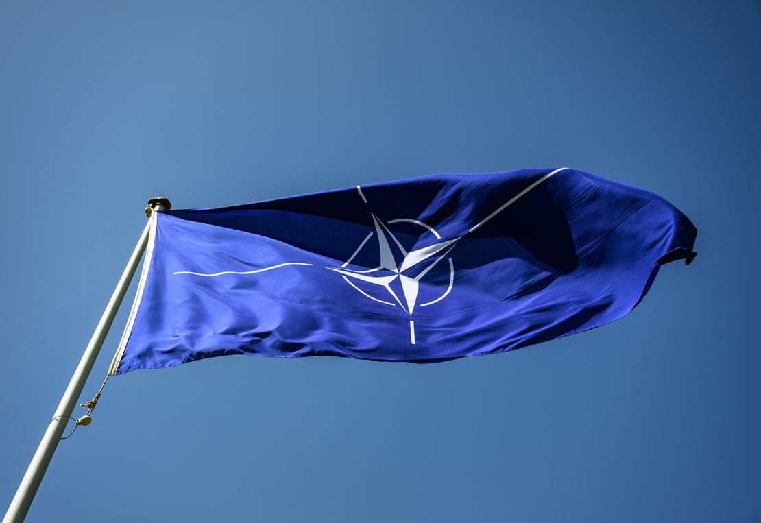 A NATO flag flies in the wind during the 