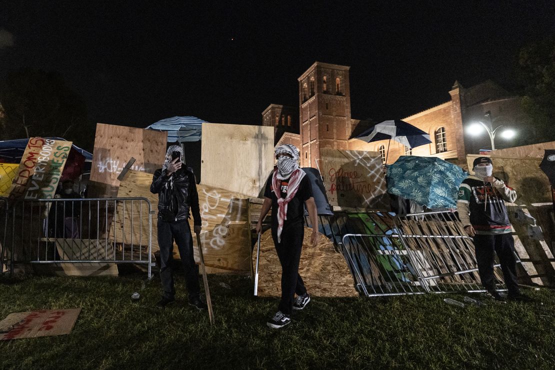 Pro-Palestinian demonstrators regroup and rebuild the barricade surrounding the encampment set up on the UCLA campus on May 1, 2024.