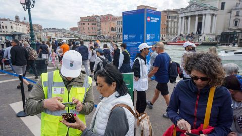 A steward checks a tourist's day access ticket near the Grand Canal, in Venice, Italy, on Wednesday, May 1, 2024. Venice, long plagued by what some observers have described as overtourism, introduced a new fee for day trippers, a world first that's likely to become a closely watched experiment as cities grapple with how to balance the wants and needs of tourists and residents. Photographer: Andrea Merola/Bloomberg via Getty Images