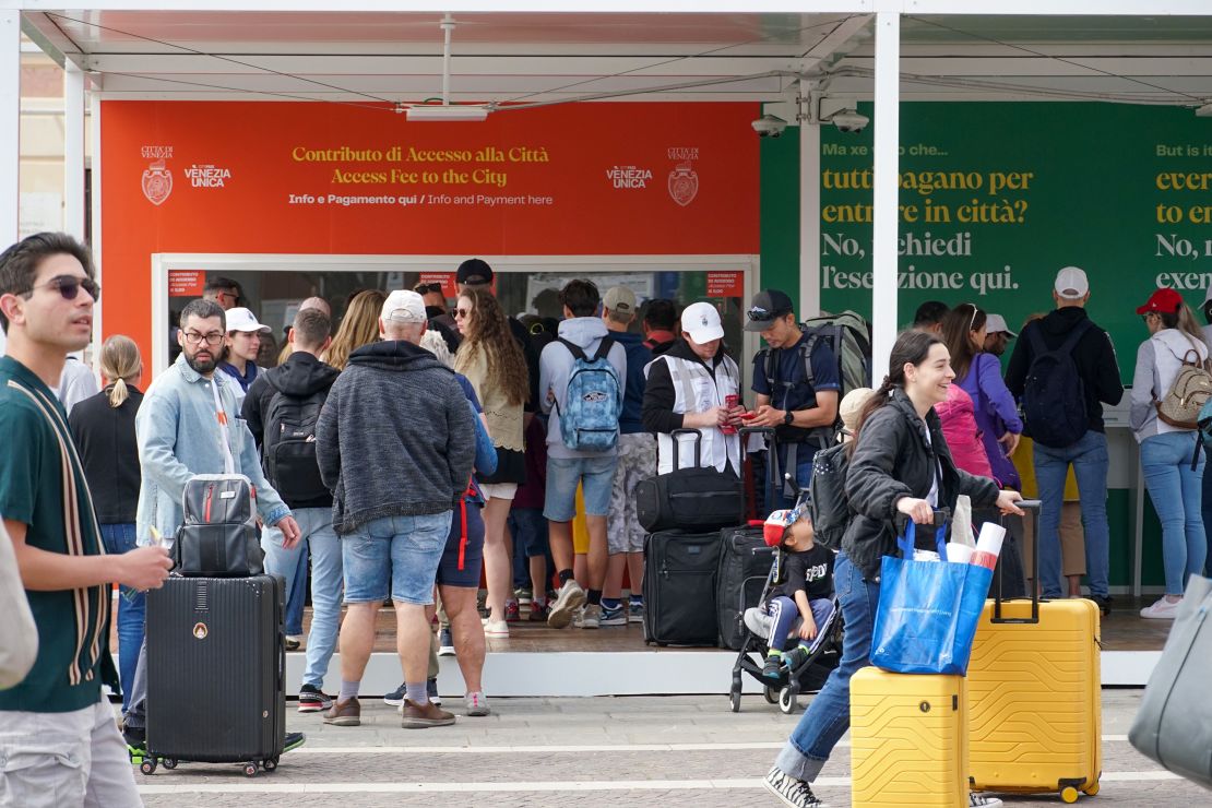 Tourists queue to pay an access fee for a day trip at an entry control point near the Grand Canal, in Venice, Italy, Wednesday, May 1, 2024. Venice, long plagued by what Described as overtourism by some observers, he introduced a new hiker fee, a world first that is likely to become a closely watched experiment as cities struggle to find a way to balance the wants and needs of tourists and residents. Photographer: Andrea Merola/Bloomberg via Getty Images