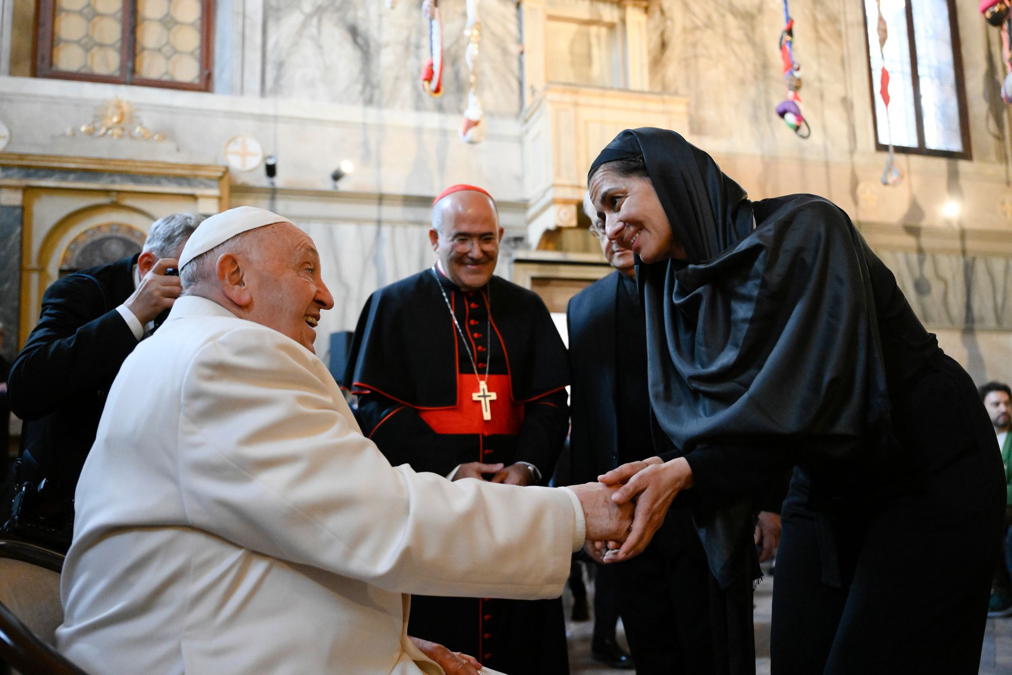 Pope Francis greets an artist in the Church of La Maddalena in the Giudecca's women's prison facility in Venice, Italy. Addressing the group, the Pope praised artists as true visionaries who can see beyond the boundaries of our world.