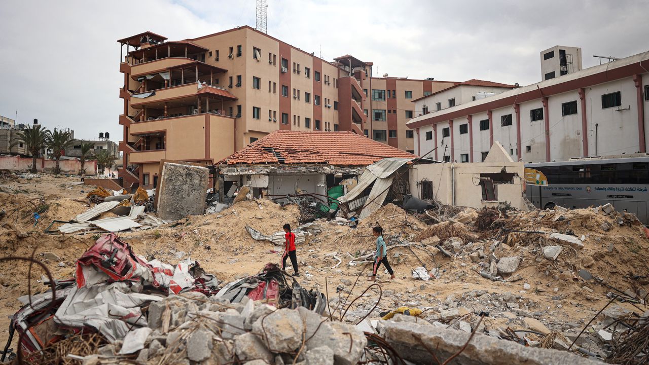 Palestinians walk on a ravaged road in front of Nasser Hospital in Khan Yunis in the southern Gaza Strip on May 2, 2024, amid the ongoing conflict between Israel and the Palestinian militant group Hamas. Israel pulled its ground forces from Khan Yunis on April 7 after carrying out a raid at the Nasser Medical Complex, one of the biggest hospitals in the Palestinian territory. (Photo by AFP) (Photo by -/AFP via Getty Images)