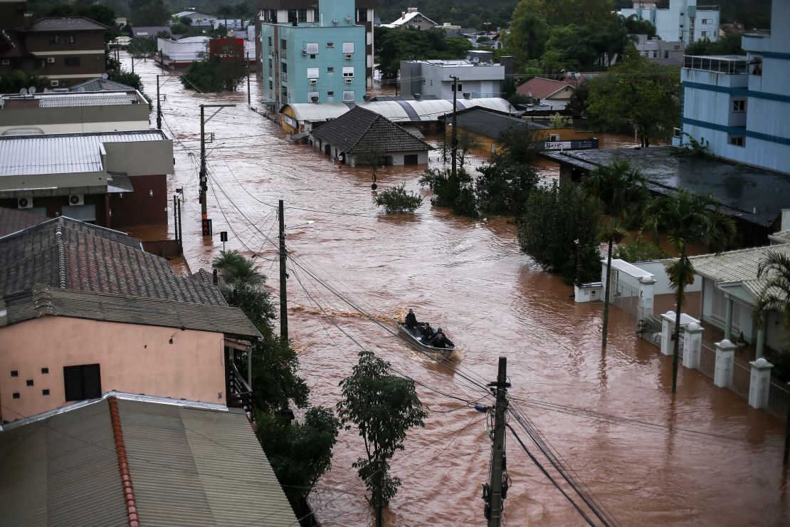 Volunteers use a fishing boat to rescue residents trapped inside their houses in São Sebastião do Cai, Rio Grande do Sul state.