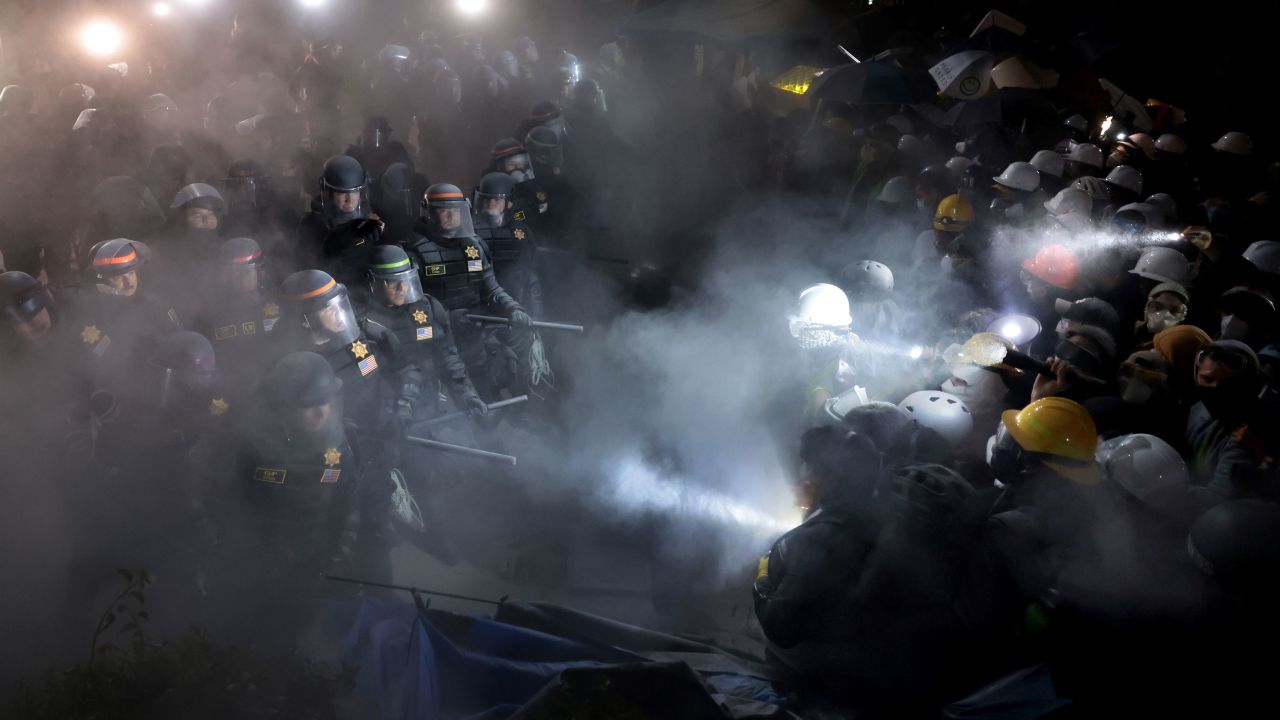 LOS ANGELES, CALIFORNIA - May 2: Police officers clash with pro-Palestinian protesters as a fire extinguisher is deployed at UCLA early Thursday morning. (Wally Skalij/Los Angeles Times via Getty Images)