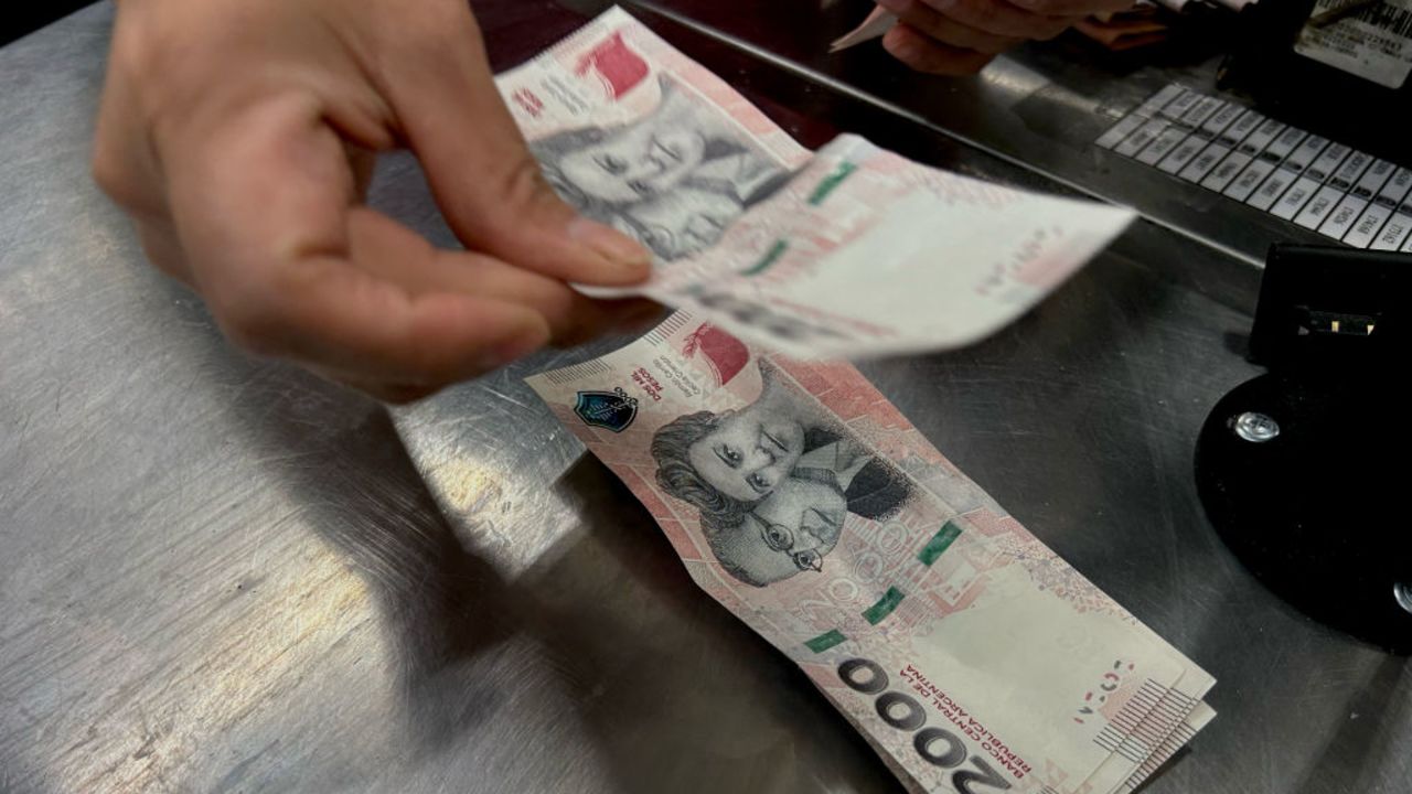 A cashier counts bank notes during a cash-draw at a supermarket in Buenos Aires on May 2, 2024. (Photo by STRINGER / AFP) (Photo by STRINGER/AFP via Getty Images)