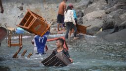 Evacuees who live at the foot of Mount Ruang volcano unload belongings from a boat after visiting their homes on Tagulandang Island in Sitaro, North Sulawesi on May 4, 2024. Mount Ruang erupted three times on April 30, spewing lava and ash more than five kilometres (three miles) into the sky and forcing authorities to issue evacuation orders for 12,000 locals. (Photo by Ronny Adolof BUOL / AFP)