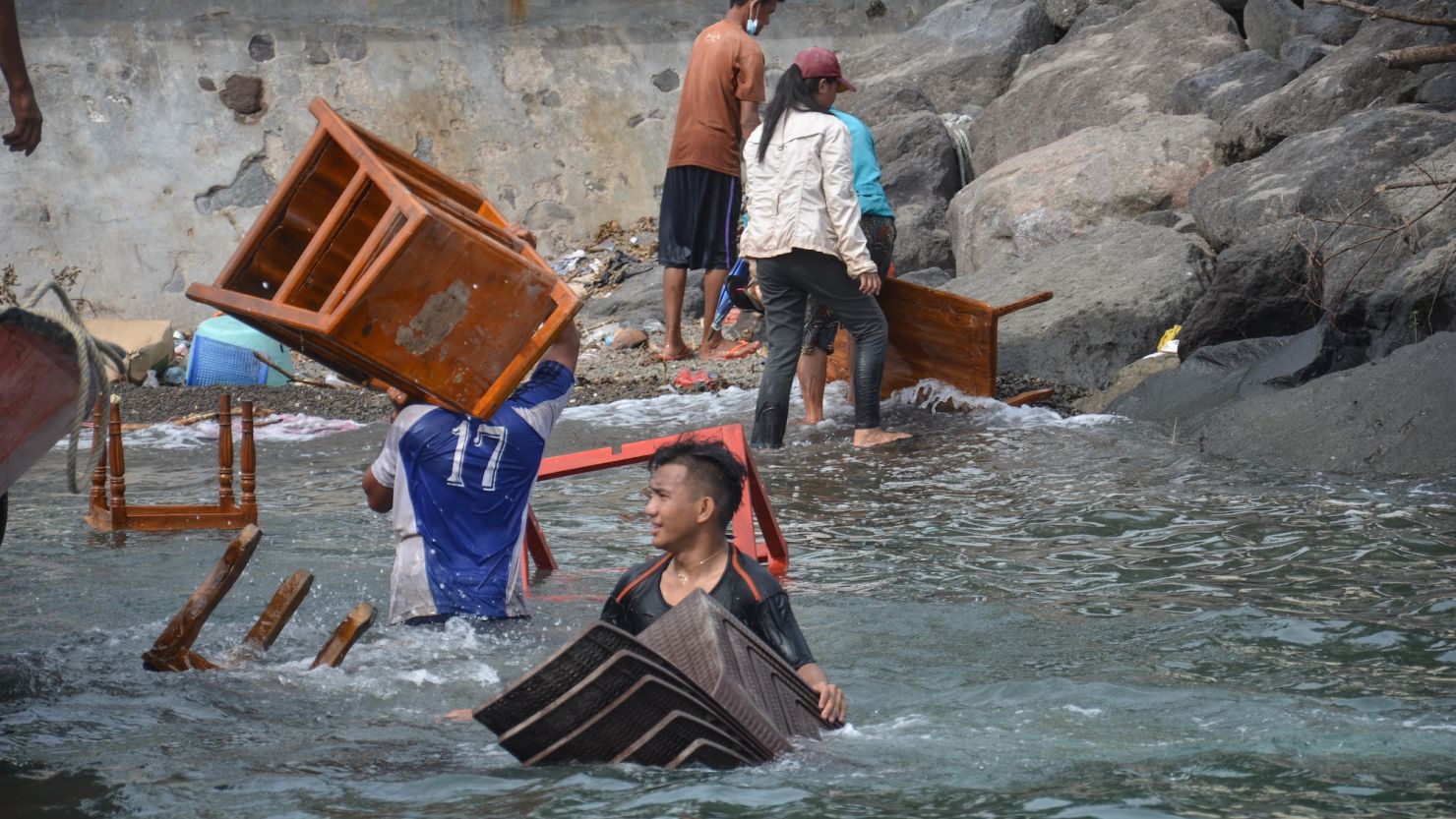 Evacuees who live at the foot of Indonesia's Mount Ruang volcano unload belongings from a boat after visiting their homes on Tagulandang Island in Sitaro, North Sulawesi, on Saturday.