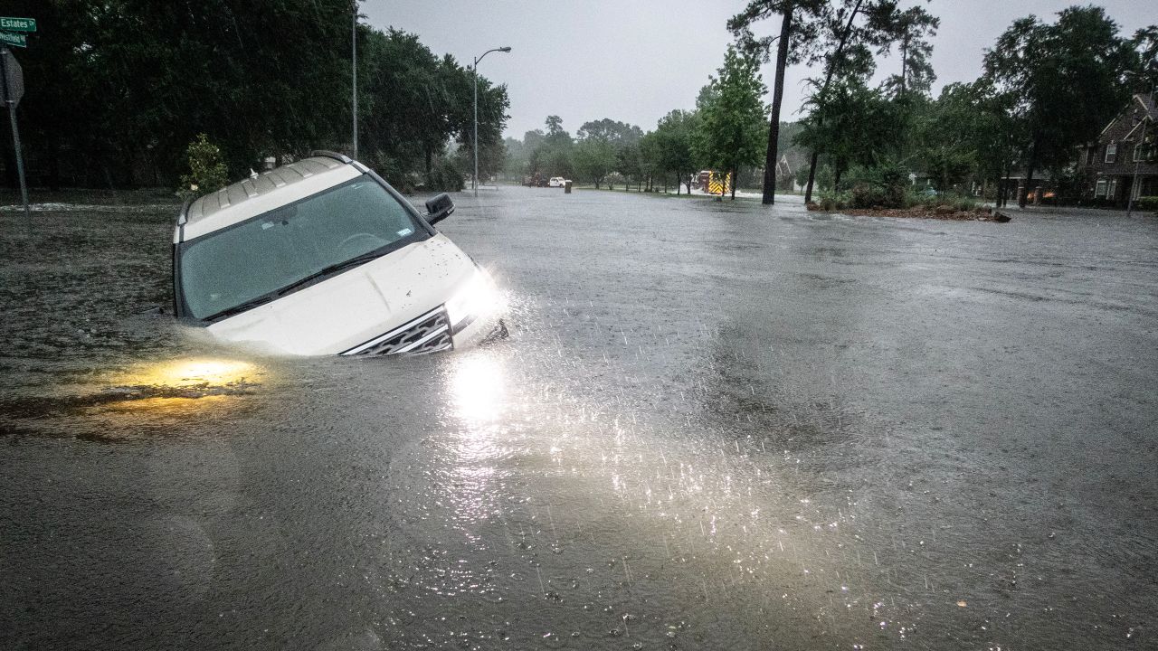 An SUV is stranded in a ditch in a stretch of street flooding during a severe storm on Thursday, May 2, 2024 in Spring.