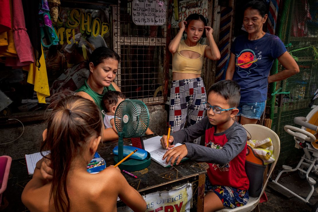 Children huddle around a small desk and mini-fan to take classes remotely as schools were shut amid extreme heat in Tondo district in Manila, Philippines on May 03, 2024. The heat index shot up to 53 degrees Celsius in some parts of the country.