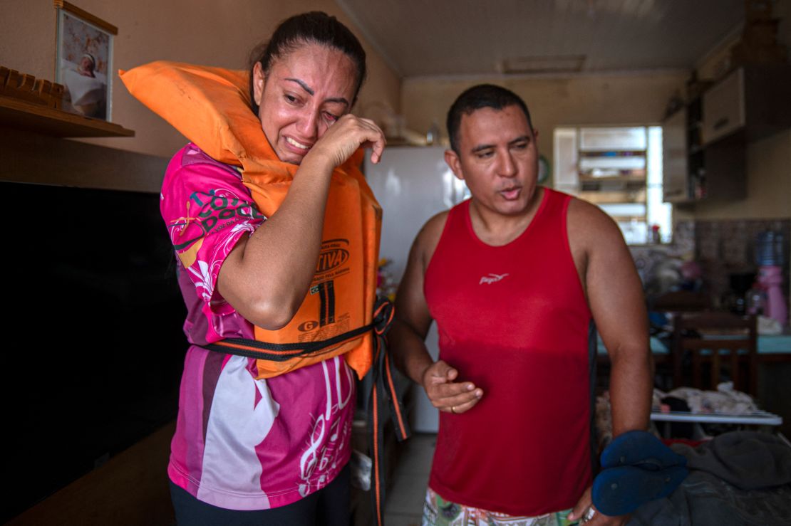 Katiane Mello, left, and her husband, James Vargas, before leaving their flooded home in Eldorado do Sul, in the state of Rio Grande do Sul, on May 9, 2024.