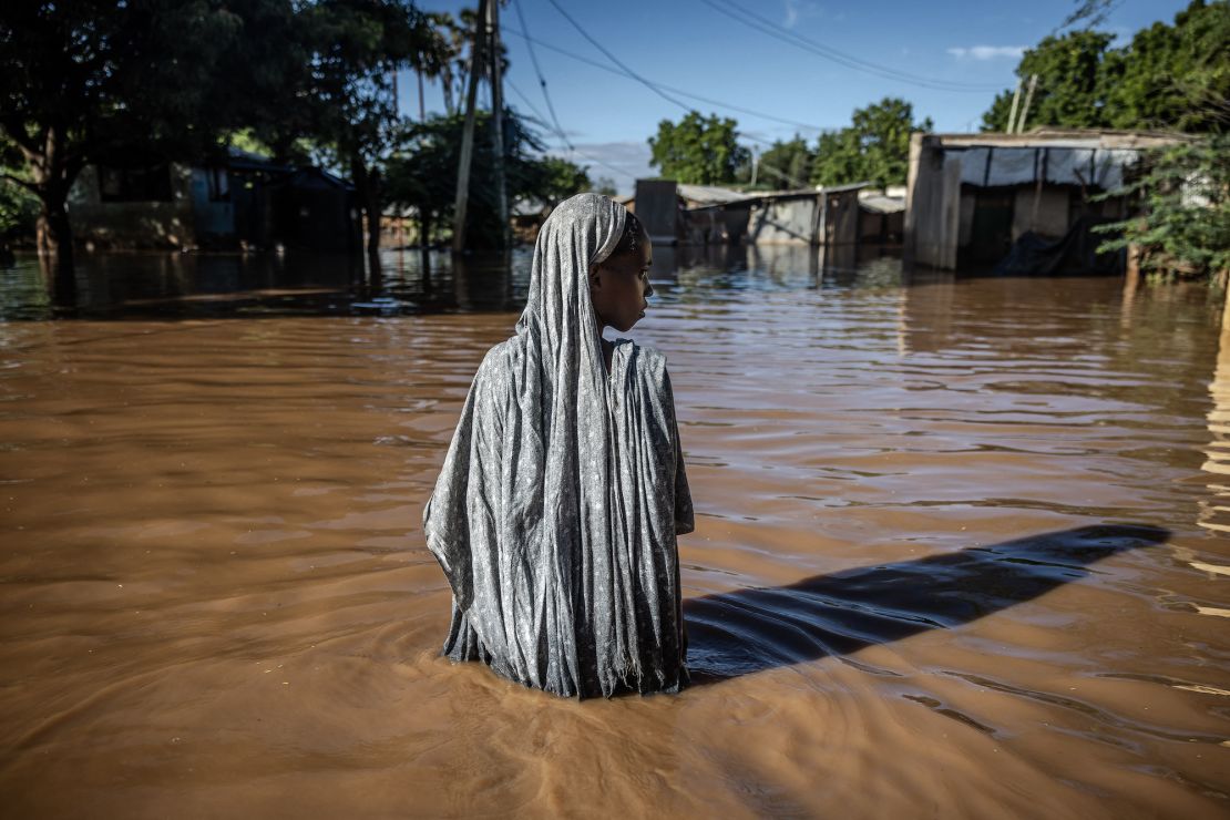 A woman wades through floodwaters at an inundated residential area in Garissa, Kenya, on May 9, 2024.