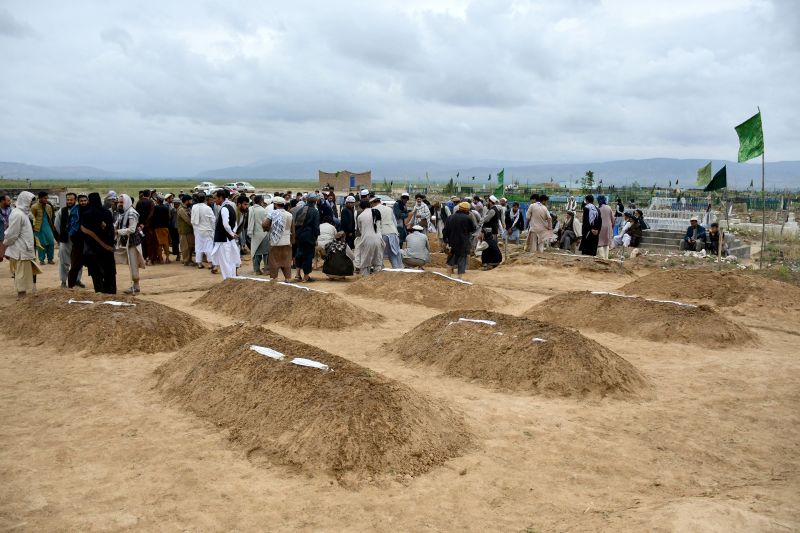 Afghan relatives offer prayers during a burial ceremony for victims of flooding in Baghlan province, May 11, 2024.