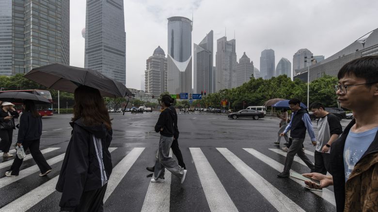 Pedestrians cross a road in Pudong's Lujiazui Financial District in Shanghai, China, on Saturday, May 11, 2024. China plans to start selling the first batch of its 1 trillion yuan ($138 billion) of ultra-long special central government bonds on Friday, according to people familiar with the matter, as it seeks to raise funds to support the world's second-biggest economy. Photographer: Qilai Shen/Bloomberg via Getty Images