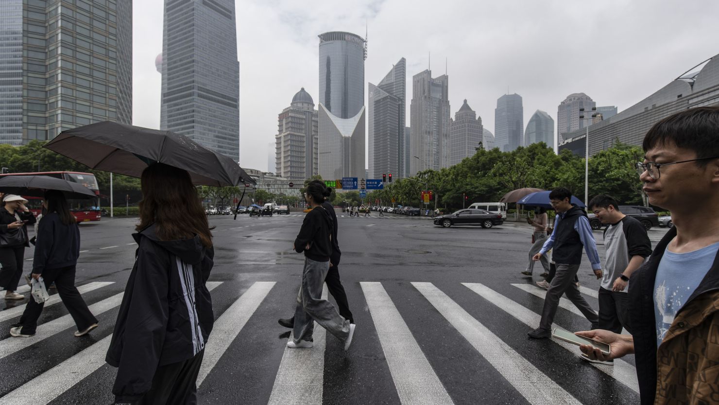 Pedestrians cross a road in Pudong's Lujiazui Financial District in Shanghai, China, on Saturday, May 11, 2024.