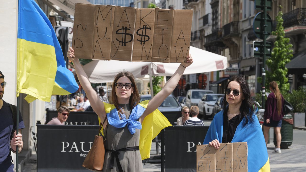 BRUSSELS, BELGIUM - MAY 13: 2 Ukrainian women holds panels during a demonstration organised by Promote Ukraine International Center for Ukrainian Victory (ICUV) near the Belgium Parliament on May 13, 2024 in Brussels, Belgium. Promote Ukraine asserts that the Russian Central Bank holds approximately $210 billion within the EU, primarily in Belgium. The organization believes, "these funds are most rightful to use for strengthening Ukraine's air defense without prolongation." (Photo by Thierry Monasse/Getty Images)