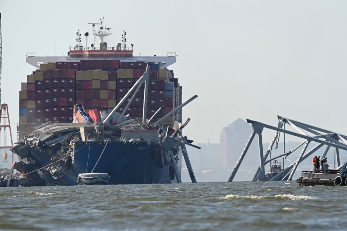 A section of the Francis Scott Key Bridge rests in the water next to the Dali container ship in Baltimore on Monday after crews conducted a controlled demolition.