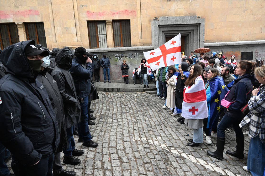 Georgian demonstrators stand in front of law enforcement officers blocking an area near the country's parliament building in Tbilisi on May 14.