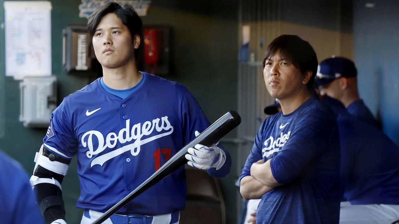 Shohei Ohtani (L) of the Los Angeles Dodgers and his then interpreter Ippei Mizuhara are pictured in the dugout during the team's spring training game in Glendale, Arizona, on March 1, 2024. Mizuhara was fired later in the month and was charged on April 11 with illegally transferring more than $16 million from one of Ohtani's bank accounts to cover gambling debts. (Photo by Kyodo News via Getty Images)