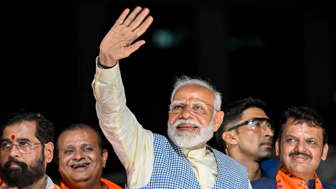 India's Prime Minister and leader of the ruling Bharatiya Janata Party (BJP) Narendra Modi (C) with chief minister of Maharashtra state Eknath Shinde (L) and their deputy chief Minister Devendra Fadnavis (R) waves to the crowd during his roadshow in Mumbai on May 15, 2024, ahead of the fifth phase of voting of India's general election.