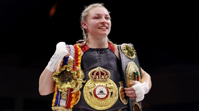 Lauren Price celebrates victory with her title belts after defeating Jessica McCaskill during the IBO and WBA World Welterweight Title fight.