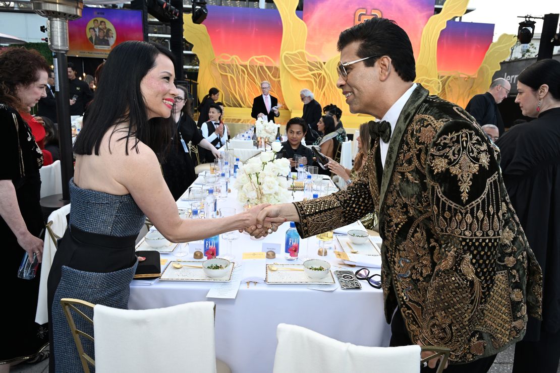 Lucy Liu, wearing a gown by Bibhu Mohapatra, and Karan Johar exchange a greeting at the Gold Gold 2024.