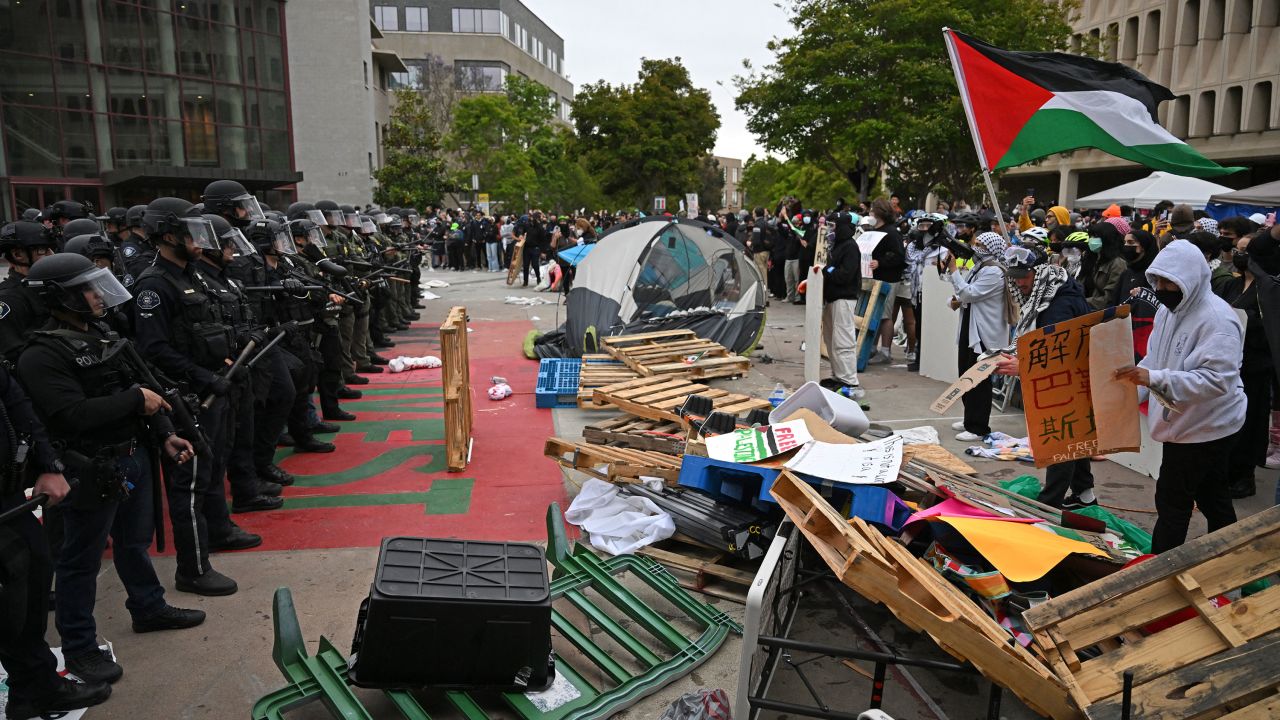 Pro-Palestinian demonstrators confront police as they clear an encampment after students occupied the Physical Sciences Lecture Hall at the University of California, Irvine, in Irvine, California on May 15, 2024.