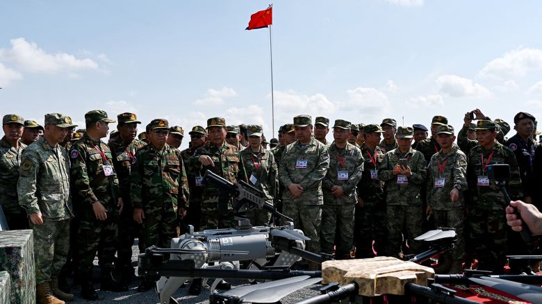 Commander-in-Chief of the Royal Cambodia Armed Forces Vong Pisen (C-L) and Chinese People's Liberation Army (PLA) Southern Theater Command's Gao Xiucheng (center R) attend a demonstration of a machine gun equipped robot battle "dog" (C) during the Cambodian-Chinese Dragon Gold-2024 drill at a military police base in Kampong Chhnang province on May 16, 2024.