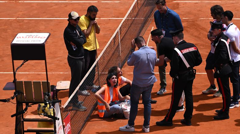 Protesters sit on court during a doubles match at the Italian Open.