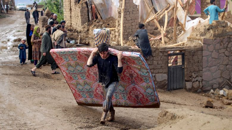 Residents clean debris and salvage their belongings after flash floods in Firozkoh, Ghor province.