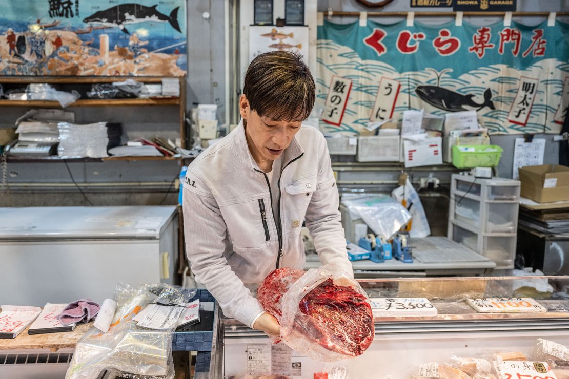 The owner of a whale meat shop shows a block of whale meat at the Karato fish market in Shimonoseki city.