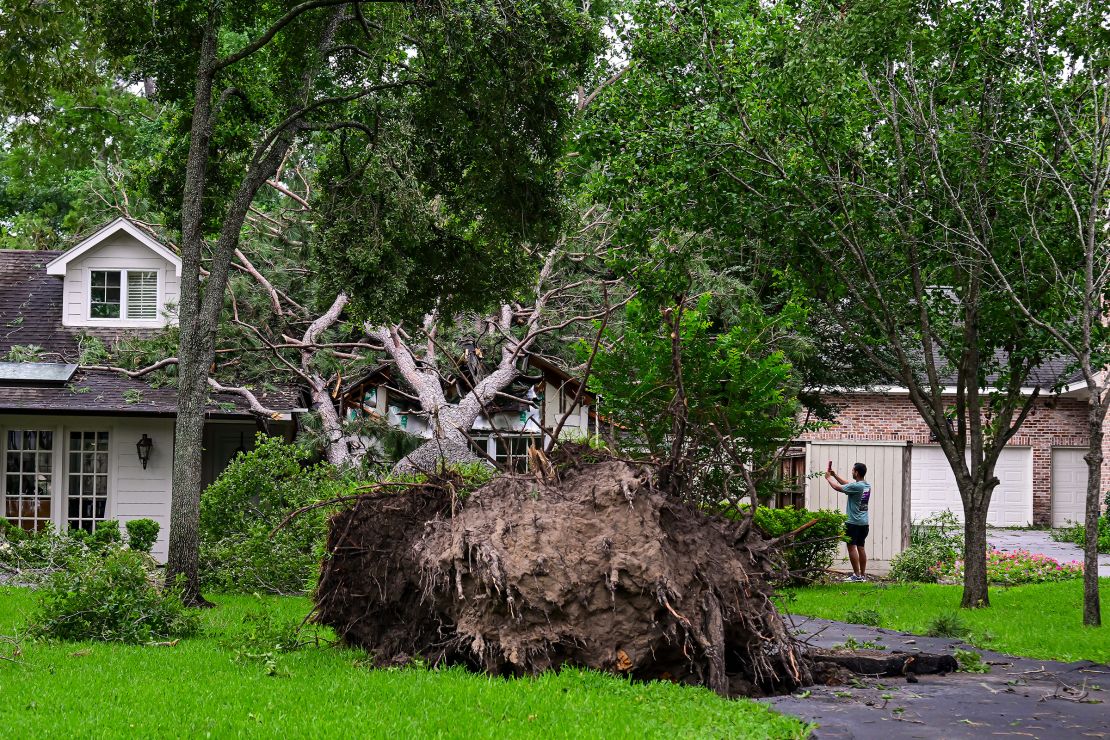 A home is severely damaged by a fallen tree after high winds and rain ravaged the Houston, Texas, area on Friday.