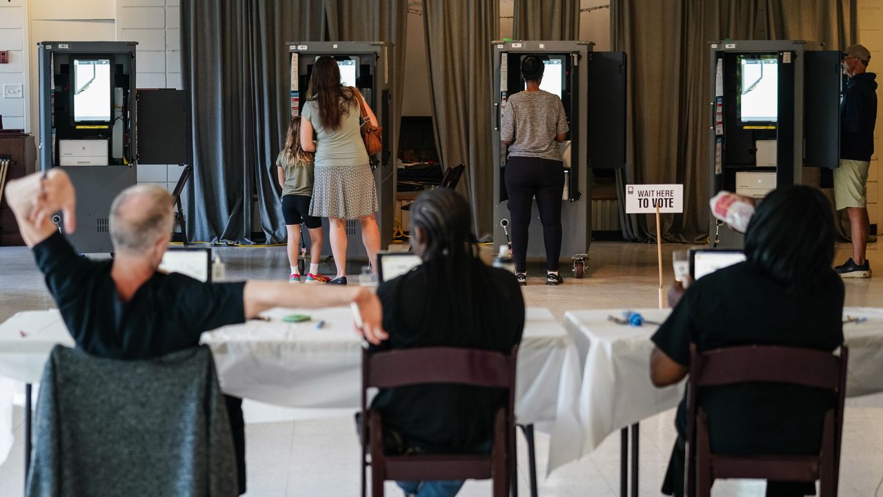 A Fulton County Elections worker stretches his arms as voters cast ballots in Georgia's primary election at a polling location in Atlanta, Georgia on May 21, 2024.