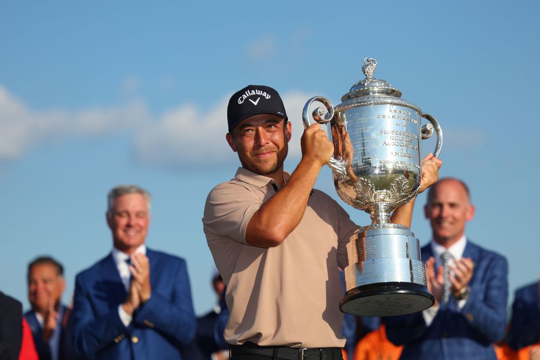 Schauffele hoists the Wanamaker Trophy aloft.