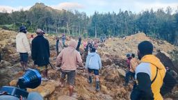 People gather at the site of a landslide in Maip Mulitaka in Papua New Guinea's Enga Province on May 24, 2024.