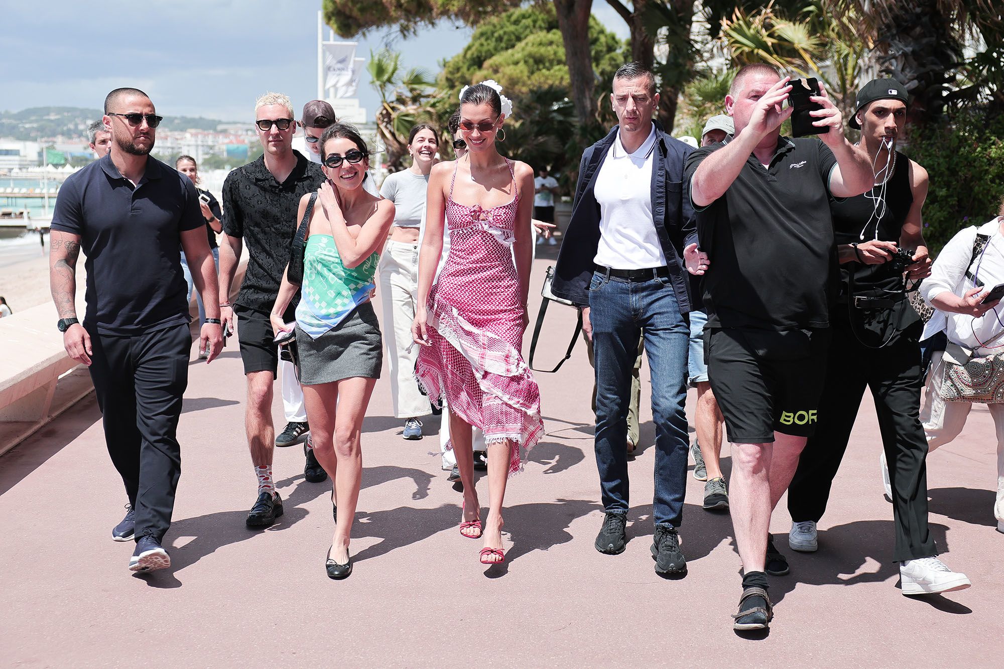 Bella Hadid (center) is seen wearing a keffiyeh-inspired dress by Michael and Hushi during the 77th Cannes Film Festival on May 23, 2024.