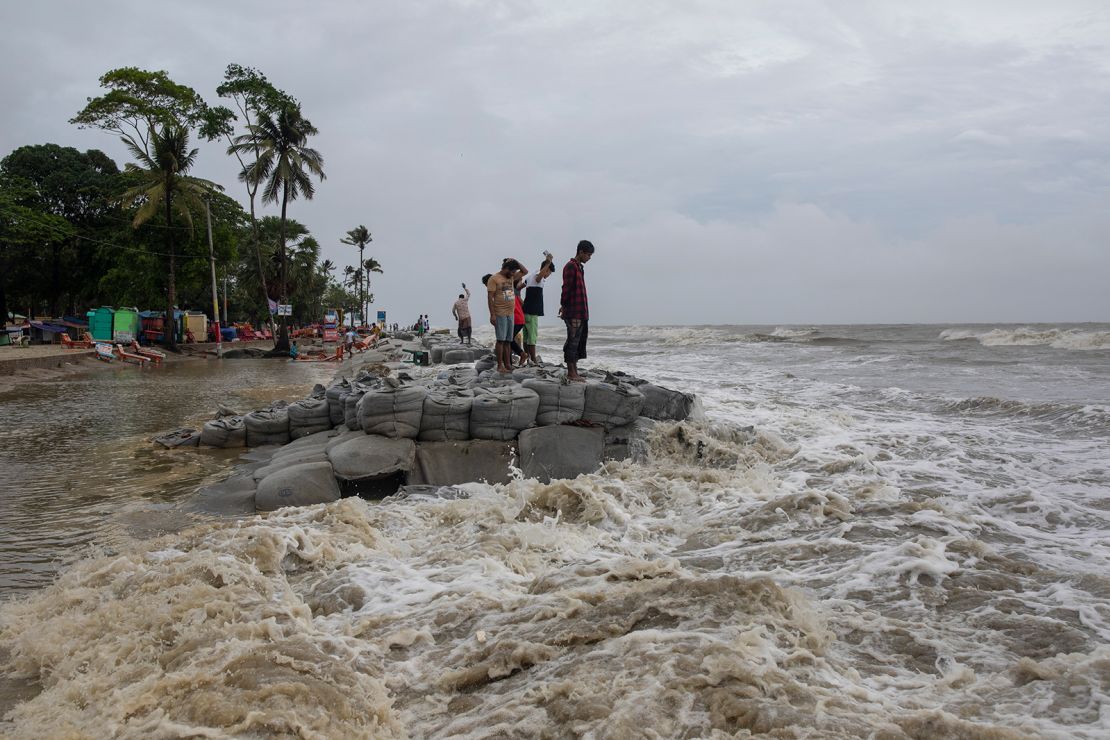 Locals stand near the sea as Cyclone Remal made landfall in Bangladesh on May 26, 2024.