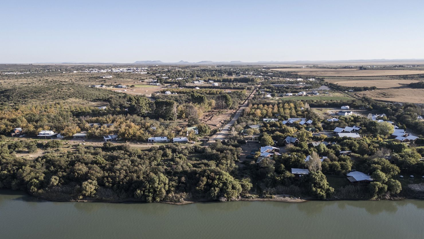 An aerial view shows agricultural land to the right, the Orange River and Orania, an "Afrikaner-only" town in South Africa's Northern Cape, on May 26, 2024.