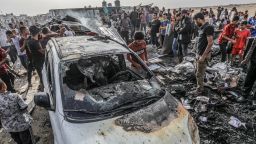 27 May 2024, Palestinian Territories, Rafah: Palestinians inspect a burnt car after an Israeli air strike, which resulted in numerous deaths and  injuries, in the Al-Mawasi area, which was bombed with a number of missiles on the tents of displaced people west of the city of Rafah in the southern Gaza Strip. Photo: Abed Rahim Khatib/dpa (Photo by Abed Rahim Khatib/picture alliance via Getty Images)