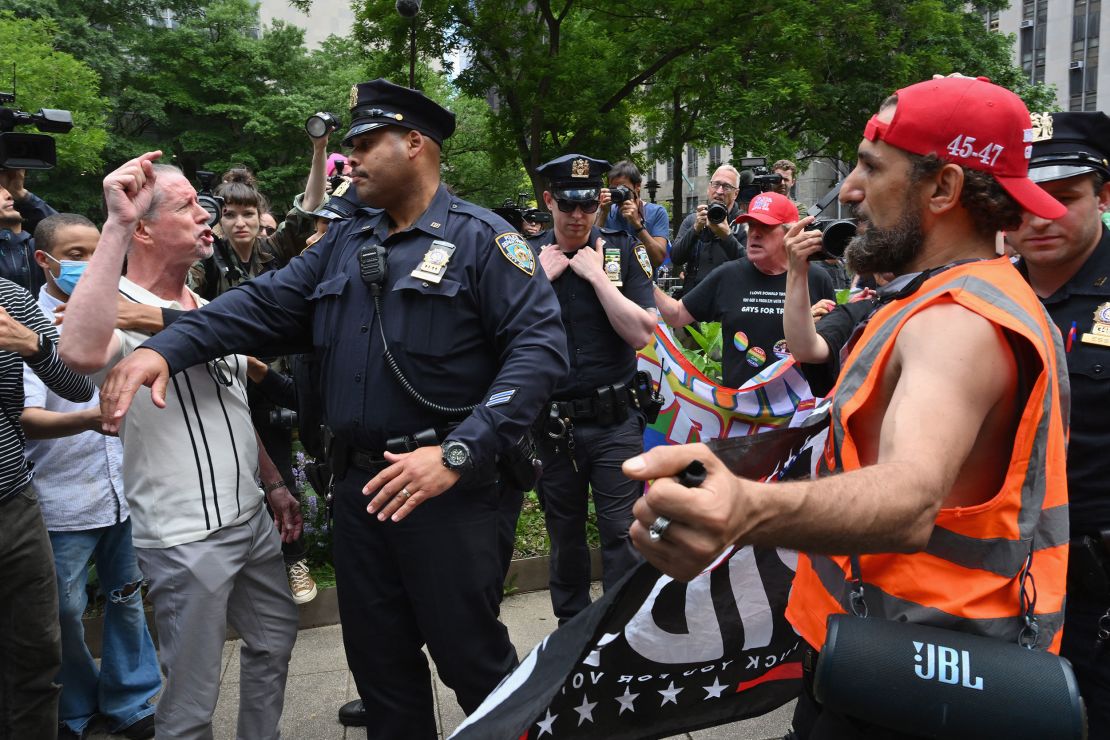 Police officers separate an anti-Trump protestor from a pro-Trump demonstrator as people wait for a verdict in the criminal trial of former President Donald Trump on May 30, 2024, in New York City.