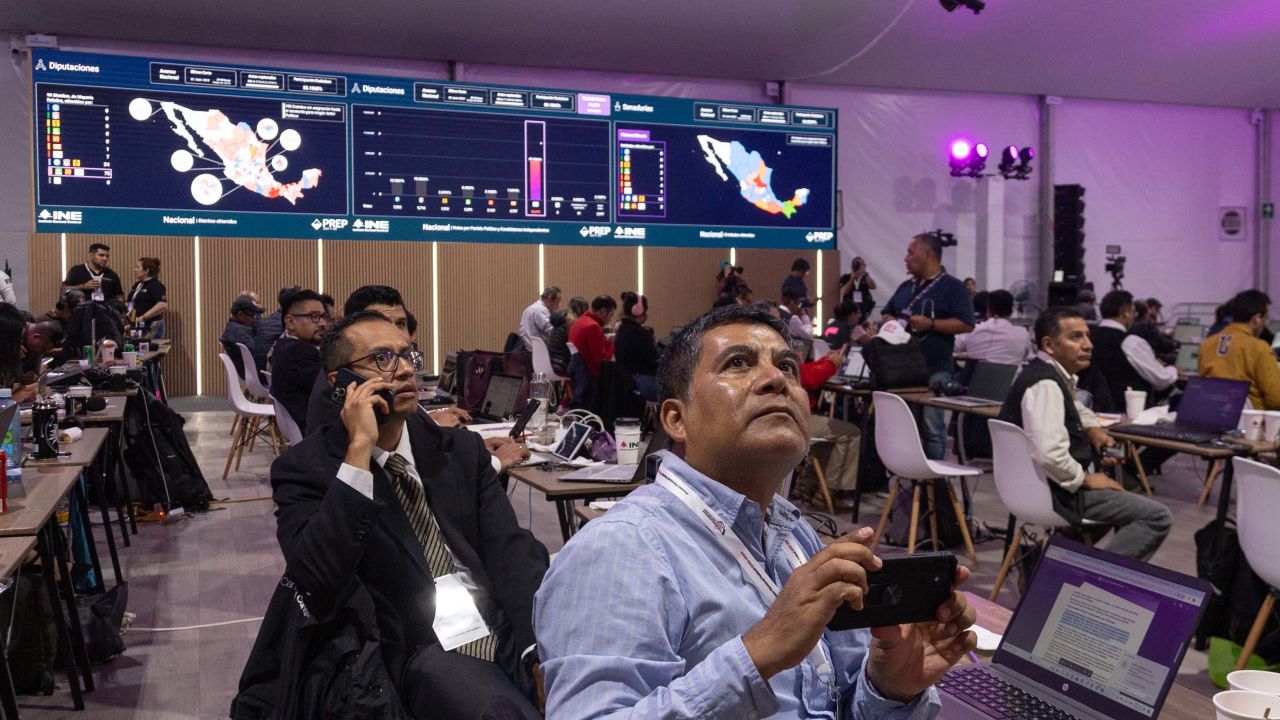 Members of the media watch a screen displaying the preliminary results of the general election in Mexico City on June 2, 2024. . Claudia Sheinbaum was set to be elected Mexico's first woman president, exit polls showed, a milestone in a country with a history of gender-based violence. (Photo by Franyeli Garcia / AFP) (Photo by FRANYELI GARCIA/AFP via Getty Images)